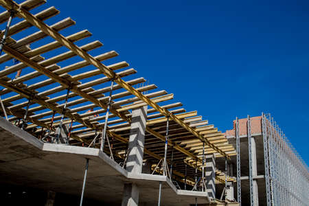 Construction site background. Hoisting cranes and new multi-storey buildings. I.ndustrial background.Building construction site work against blue skyの写真素材
