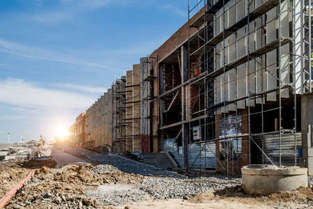 Construction site background. Hoisting cranes and new multi-storey buildings. I.ndustrial...
