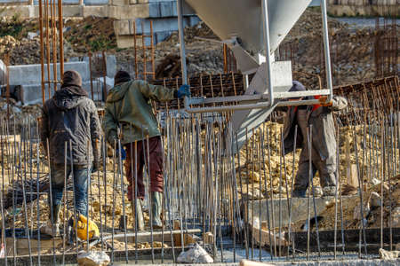 Pouring cement during for construction from concrete mixer truck car.Construction workers in the...