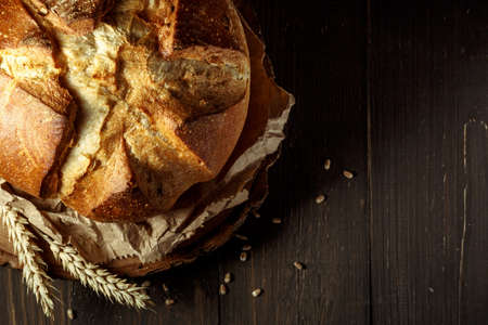 freshly baked bread on dark gray kitchen table, top view, with copy space. Whole grain rye bread...