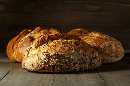 Freshly baked traditional bread on wooden table, with copy space, food closeup. Whole grain rye...