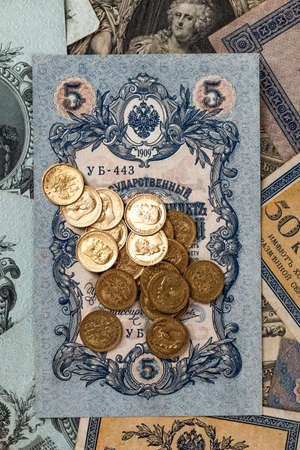 Gold and silver coins of the Russian Empire19 - 20 century in the background kopyur.Five rubles...
