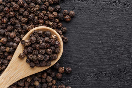 Peppercorn background. Dry black pepper seeds. Top view.On a black background. free space for your text.の写真素材