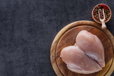 Raw chicken fillet with spices. Food background, cooking ingredients. Fresh meat. Chicken breast.on black background, top viewの写真素材
