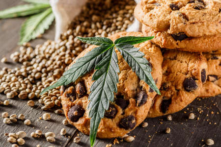 Cookies with cannabis and buds of marijuana on the table. A can of cannabis buds CBD Concept of cooking with cannabis herb. - Medical Legal Marijuanaの写真素材
