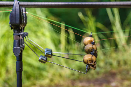 Fishing adventures, Carp rods with skull-shaped bite indicators mounted on a rod by a lake river.Professional fishing equipmentの写真素材