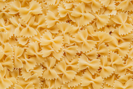Traditional Italian farfalle pasta. Italian Cuisine. Bow tie noodles. Uncooked dried farfalle. Butterfly. Top view.の写真素材