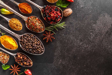 Various spices a vintage spoons on stone table. Colorful Herbal and Spices Oriental marketplace.Top view. Cafe concept. Delicious food delivery.の写真素材