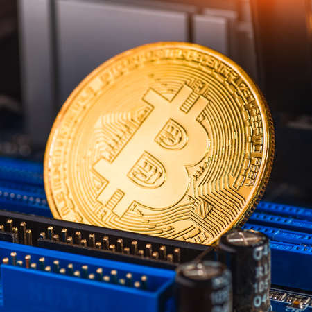 Golden Bitcoin Cryptocurrency on computer circuit board. Macro shotの写真素材