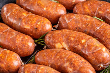Grilled sausages, homemade, cast iron skillet or frying pan with tomatoes, garlic and rosemary. Brazilian barbecue. copy spaceの写真素材