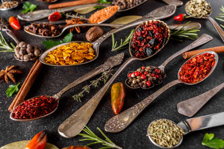 Various spices a vintage spoons on stone table. Colorful Herbal and Spices Oriental marketplace.Top view. Cafe concept. Delicious food delivery.の写真素材
