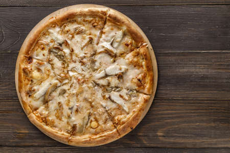 Fresh pizza with, black olives, mozzarella cheese, ham on wooden table closeup. Space for text or copy space. Pizza menu. Restaurant menu advertiseの写真素材