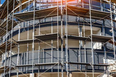 Extensive scaffolding providing platforms for work in progress on a new apartment block, Tall...