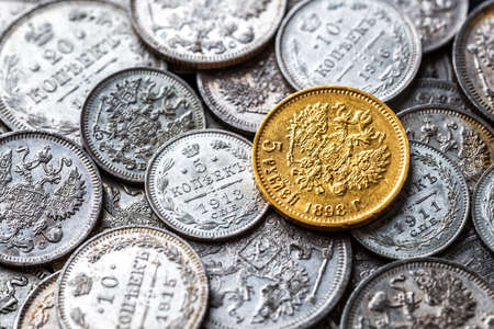 Gold and silver coins of the Russian Empire19 - 20 century in the background kopyur.Five rubles...