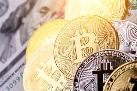 Golden Bitcoin lies on the banknotes.New virtual money. Crypto currency top view. Real coins of...