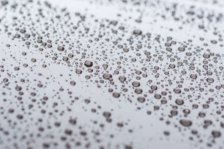 Pattern of water drops in a shining metallic surface with sky reflections, Water droplet on the car hood. Realistic pure water droplet water drops for creative banner designの写真素材