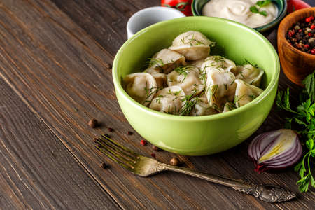 Pierogi or pyrohy, varenyky, vareniki, dumplings served with caramelized salted onion in bowl on wooden table - Traditional russian food- pelmeni, ravioliの写真素材