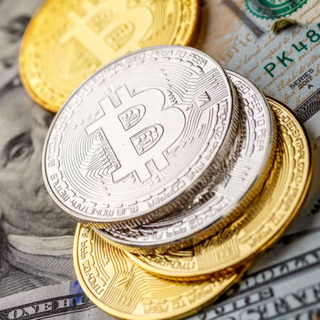 Golden Bitcoin lies on the banknotes.New virtual money. Crypto currency top view. Real coins of...