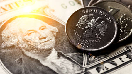 Russian ruble coin on background of dollar bill.Concept of ruble devaluation, inflation in Russia.The concept of depreciation, sanctions, financial crisis, war.Stop war.の写真素材