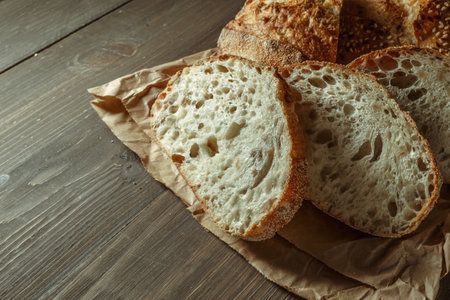 Bread, traditional sourdough bread cut into slices on a rustic wooden background. Concept of traditional leavened bread baking methods. Healthy food.の写真素材
