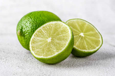 Green lime with cut in half and slices isolated on white background.Healthy green foods - alternative medicine involve a balanced diet with vitamins, nutritions and superfoods for human well-being.の写真素材