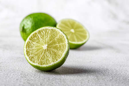 Green lime with cut in half and slices isolated on white background.Healthy green foods - alternative medicine involve a balanced diet with vitamins, nutritions and superfoods for human well-being.の写真素材