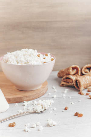 Pancakes with cottage cheese filling are on the table, next to a large bowl of homemade cottage cheese.の写真素材
