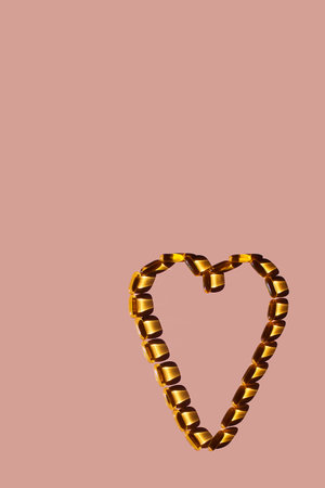 On a pink background, capsules with Omega 3, fish oil, are laid out in the shape of a heart. Vitamins. The concept of a healthy lifestyle, love of the sun.の写真素材