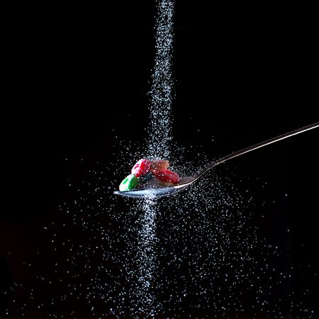 Sugar poured on cereal in a spoonの写真素材