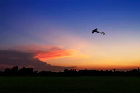 Small kite flying in the sunsetの写真素材