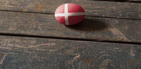 Denmark flag on a painted egg on a wooden board. Easter in Denmark Painted eggs. Easterの写真素材