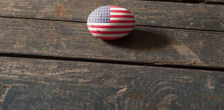 USA flag on a painted egg on a wooden board. Easter in the USA. painted eggs. Easterの写真素材