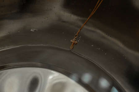 Pectoral cross in the font before the baptism of the child. Concept: religion, travel, architectureの写真素材