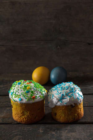 In the foreground there are 2 Easter cakes, in the back there are Painted eggs for Easter in the...