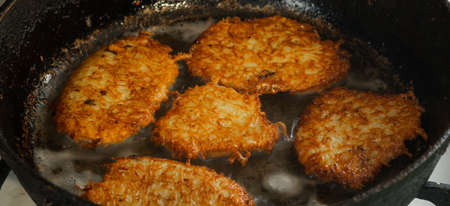Pancakes are fried in oil in a frying pan. food, potato pancakes, dish