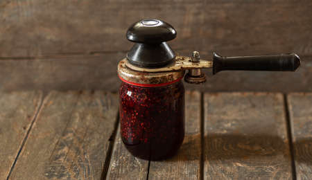 Closing the lid on a jar of raspberry jam. Preservation, cooking, foodの写真素材