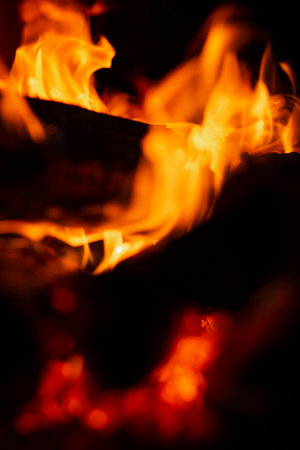 Burning firewood in the fireplace in the oven. fire texture on black backgroundの写真素材