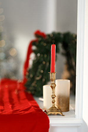 Red candle in a golden candlestick on the tableの写真素材