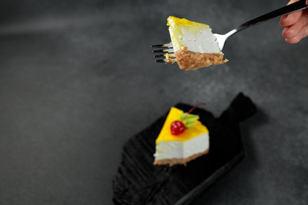 Lemon cheesecake topped with cherries, set against a sleek black background. A mouthwatering visual...