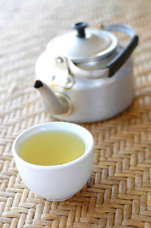 Tea cup and jug on basketwork plateの写真素材