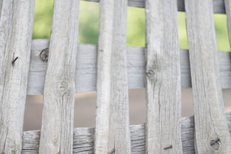 The wooden fence light against a green grass can be used as a backgroundの写真素材