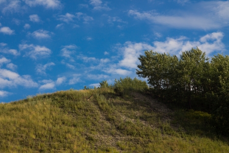 Summer landscape a vytsvevshy grass against the blue sky in cloudsの写真素材