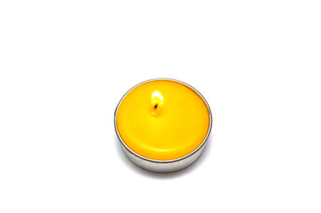 Yellow scented tea candle on white background の写真素材