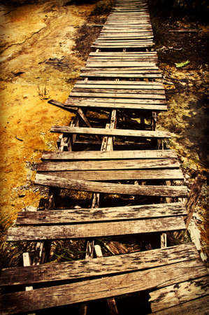 Rickety wooden bridge on the way の写真素材