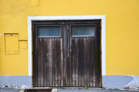Wooden door at yellow wall の写真素材