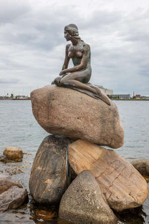 Copenhagen, Denmark - 10 August 2012: The Little Mermaid Statue by Edvard Eriksen, 1913, iconic symbol of Copenhagen sitting on a rock in the harbor looking out to sea at the Langelinie promenade.のeditorial素材