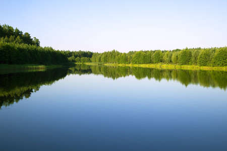 Blue sky with the sun over the water and scenic forests and rivers