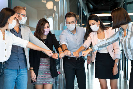 in the pandemic people greet each other at work with new normal wayの写真素材