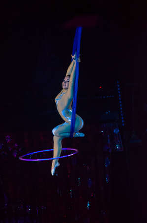 DNIPRO, UKRAINE - DECEMBER 13, 2019:  Aerial gymnast on cor de volan with hula hoop Ponomarenko Sofia performs at the Circus.のeditorial素材