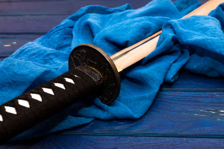 japan katana sword on the wood background with the blue shawl